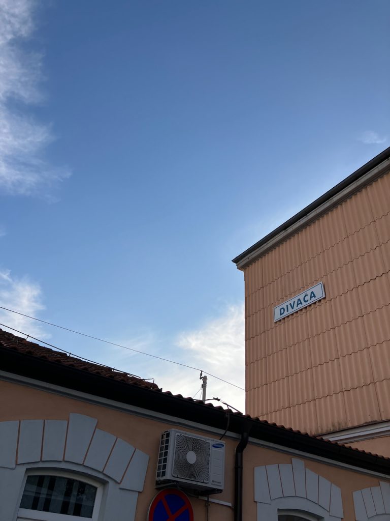 Bahnhofsschild Divača, blauer Himmel