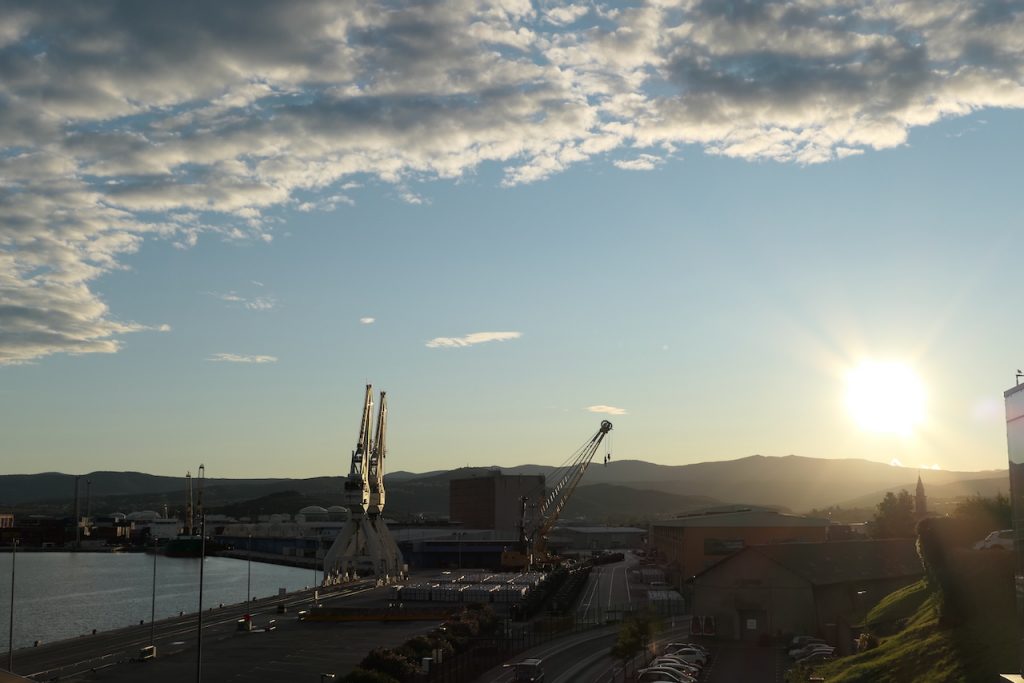 Hafenkräne im Gegenlicht der aufgehenden Sonne.