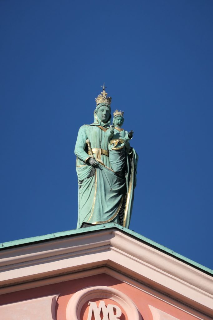 Statue der Mutter Gottes mit Jesuskind auf einem Dachfirst