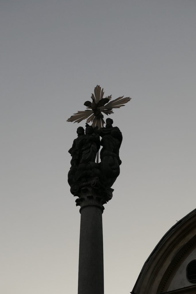 Statuen mit Kreuz auf einer Säule