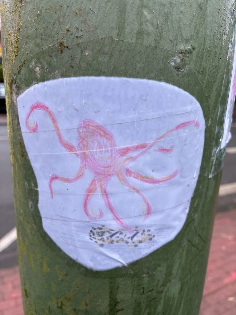 Farbige Zeichnung eines Kraken mit lächelndem Gesicht.