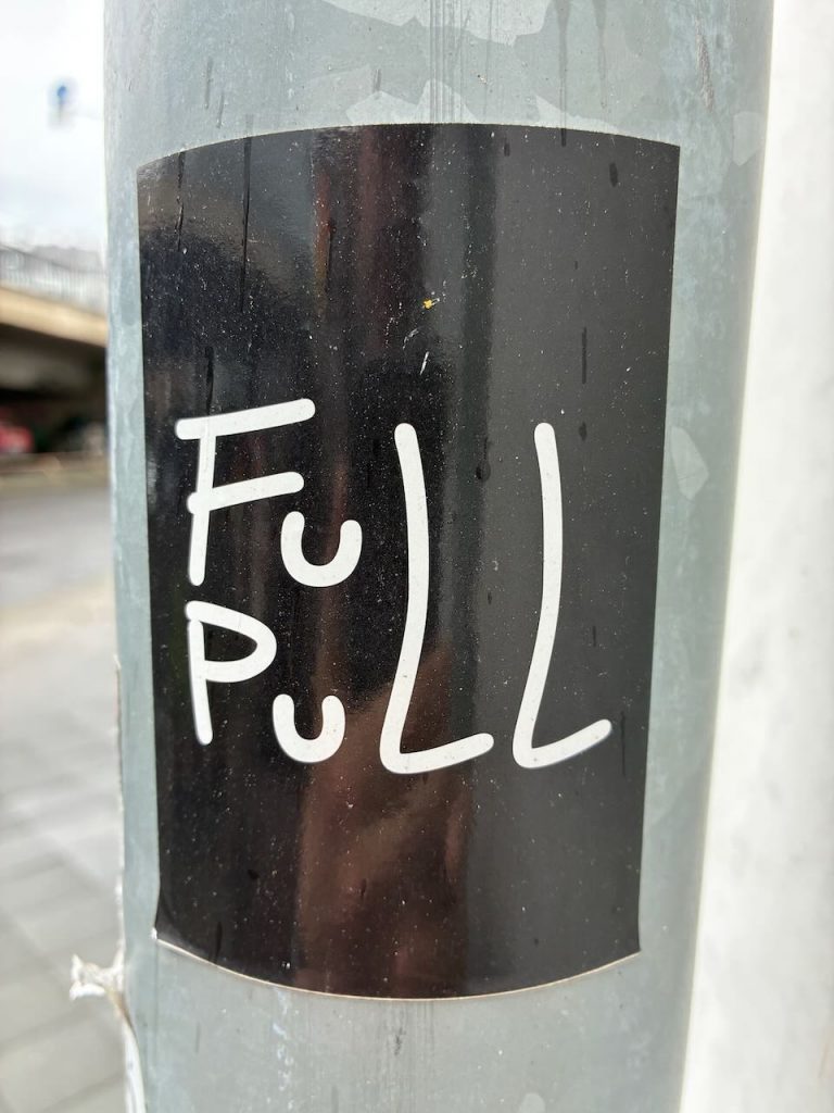 Schwarzer Sticker mit weißer, handgeschriebener Aufschrift „FULL PULL“. Die Buchstaben sind locker und unregelmäßig angeordnet.