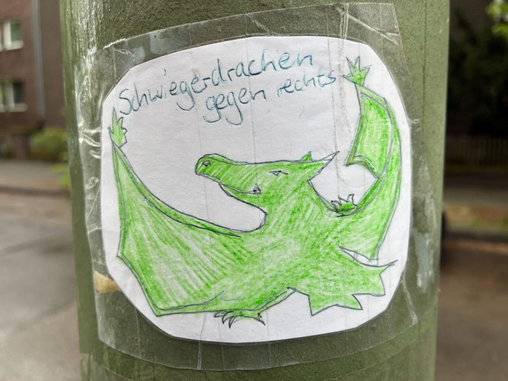 Handgezeichneter, grüner Drache mit ausgebreiteten Flügeln. Darüber steht „Schwiegerdrachen gegen rechts“.